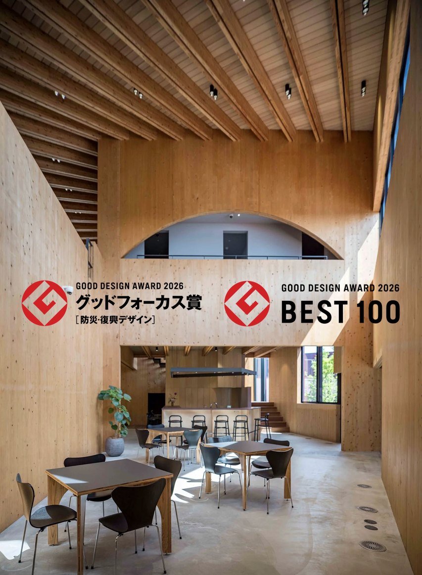 アーチ状の開口がある吹抜けと食堂スペース。グッドフォーカス賞［防災・復興デザイン］とベスト100のロゴ入り